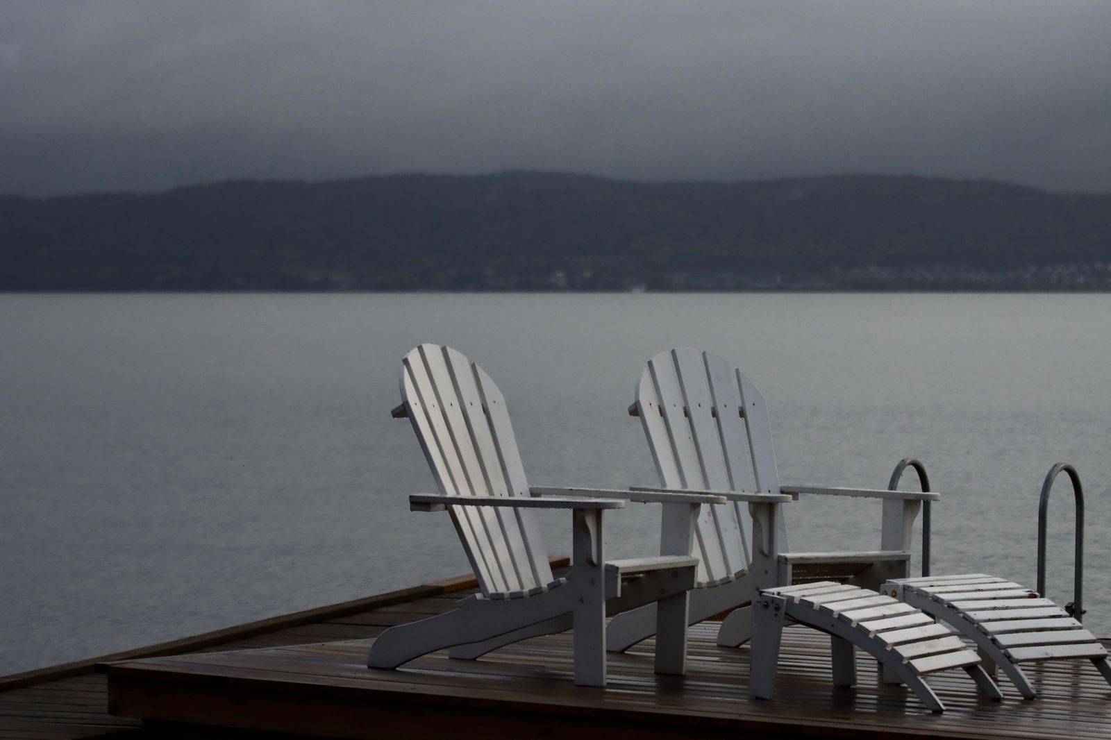 Muskoka chairs on a dock at a lakeside cottage