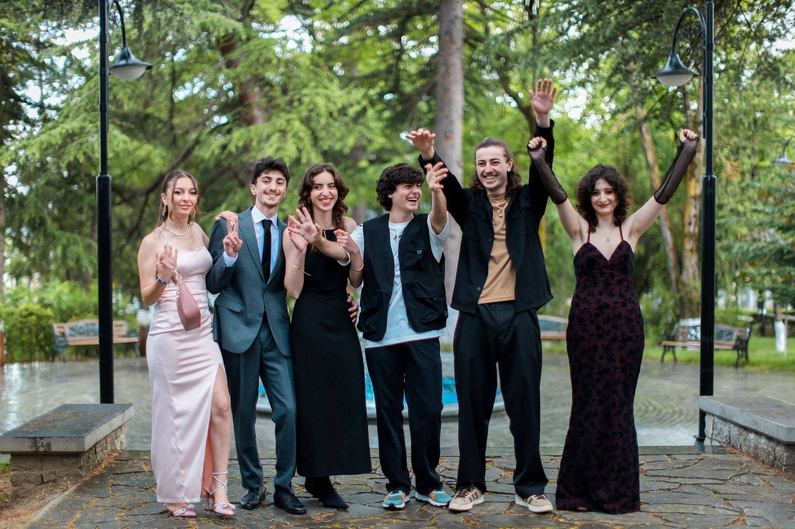 A group of friends dressed for an evening out beside a waiting limousine