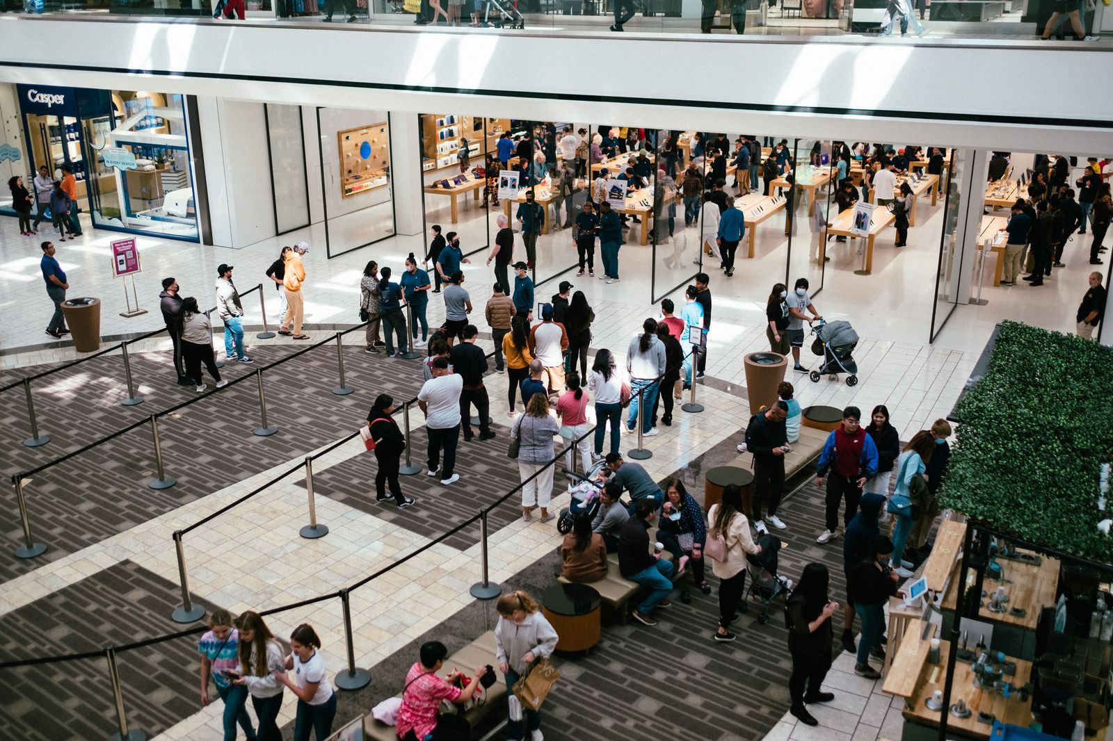 Shoppers walking through a large indoor shopping mall concourse