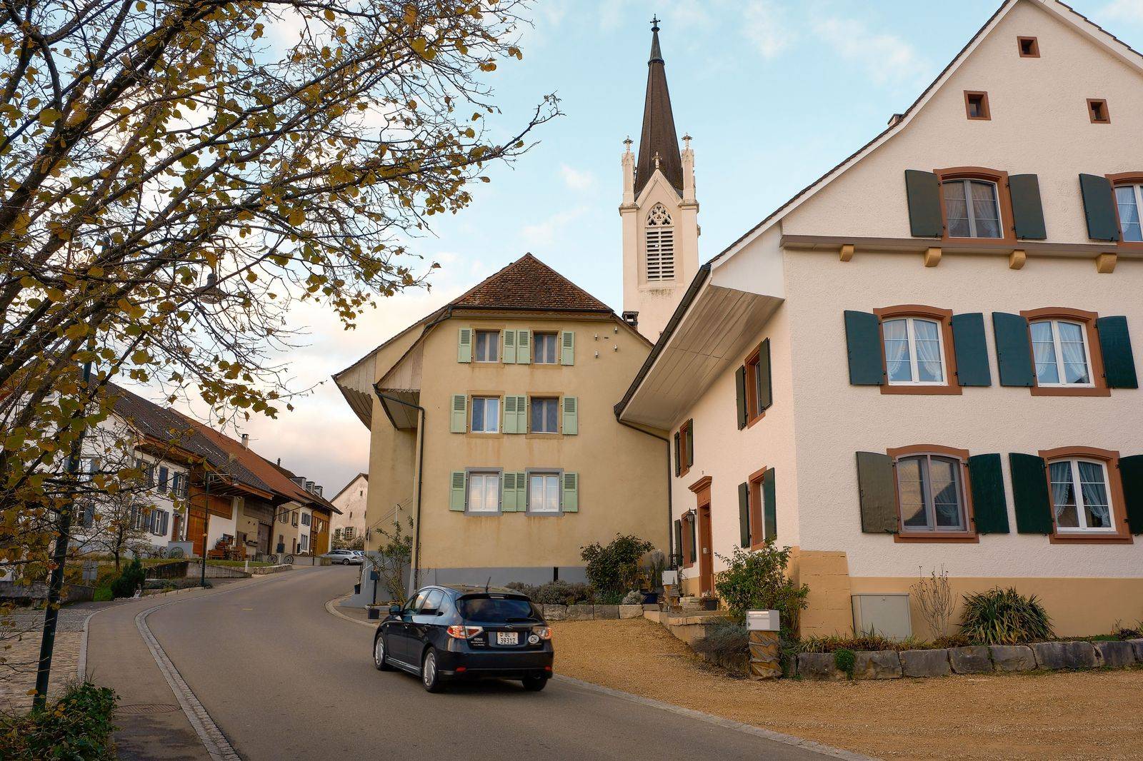 A quiet village main street with shops and trees in autumn colours