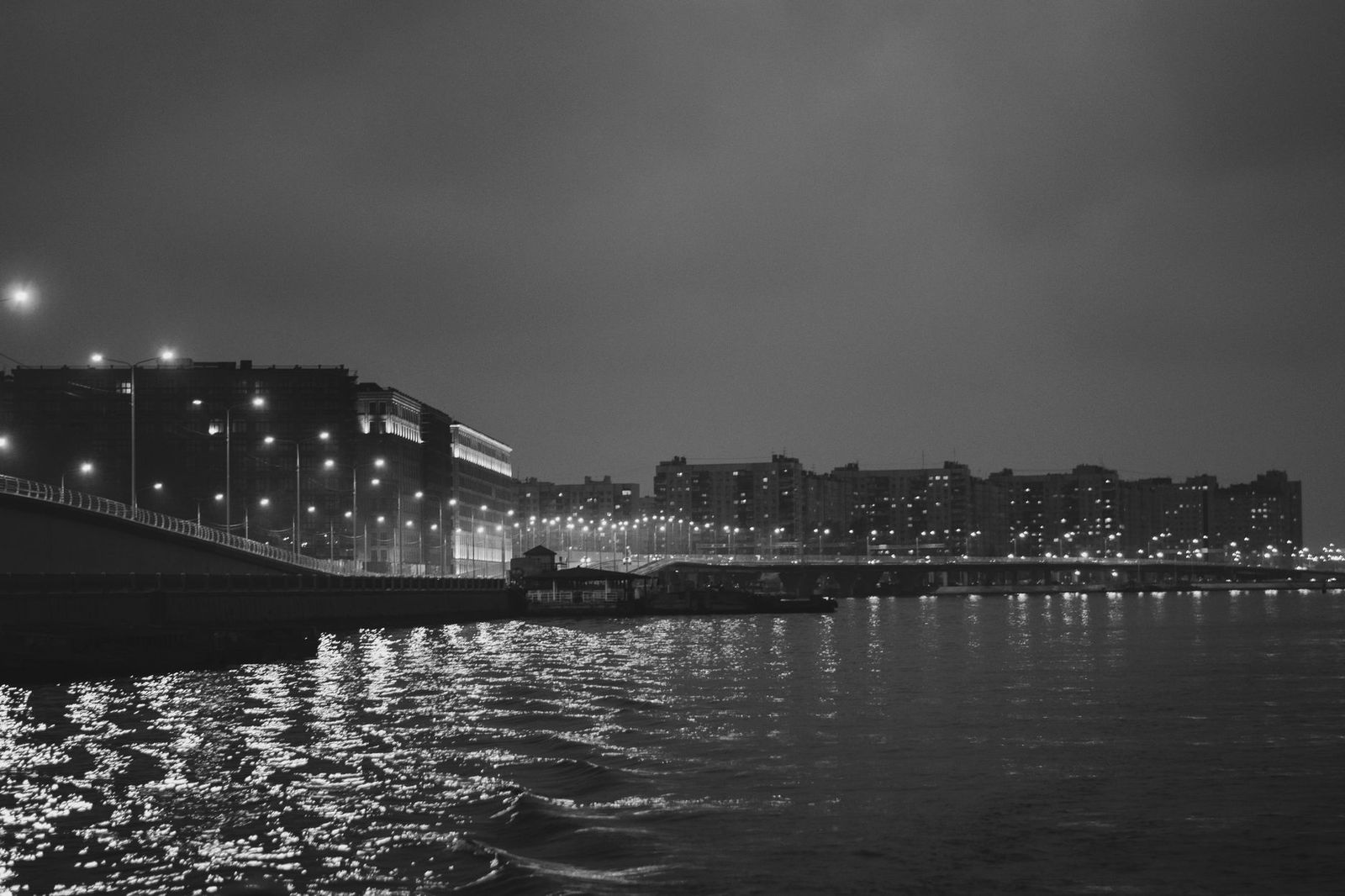 A black sedan at night on a waterfront road in Toronto after a gala