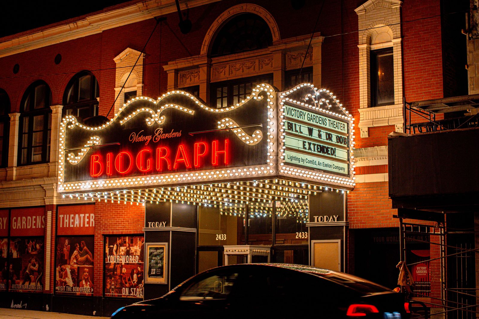 Theatre marquee lights glowing on a city street at night