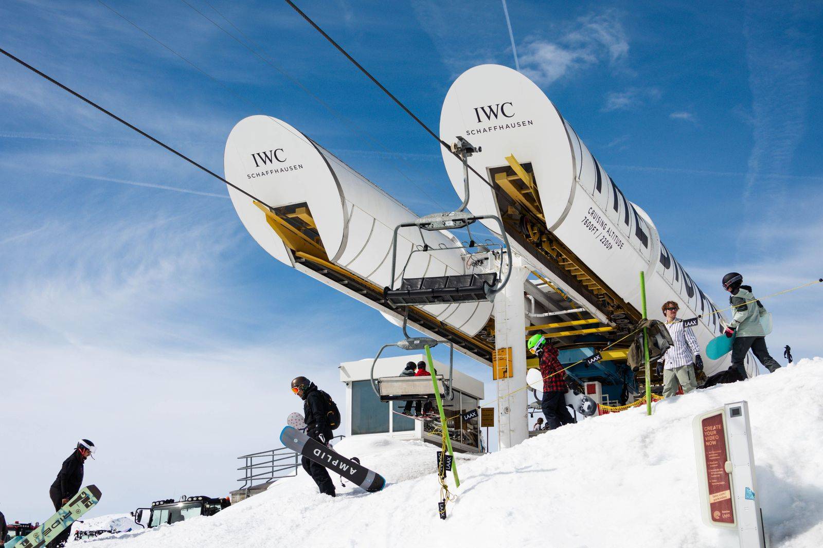 Snowboarders walking through a ski village with their boards