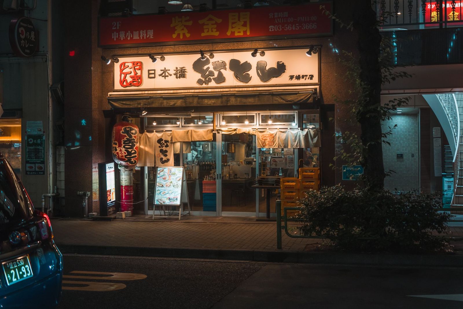 The entrance of a downtown Toronto restaurant in the evening where a chauffeur sets down dinner guests