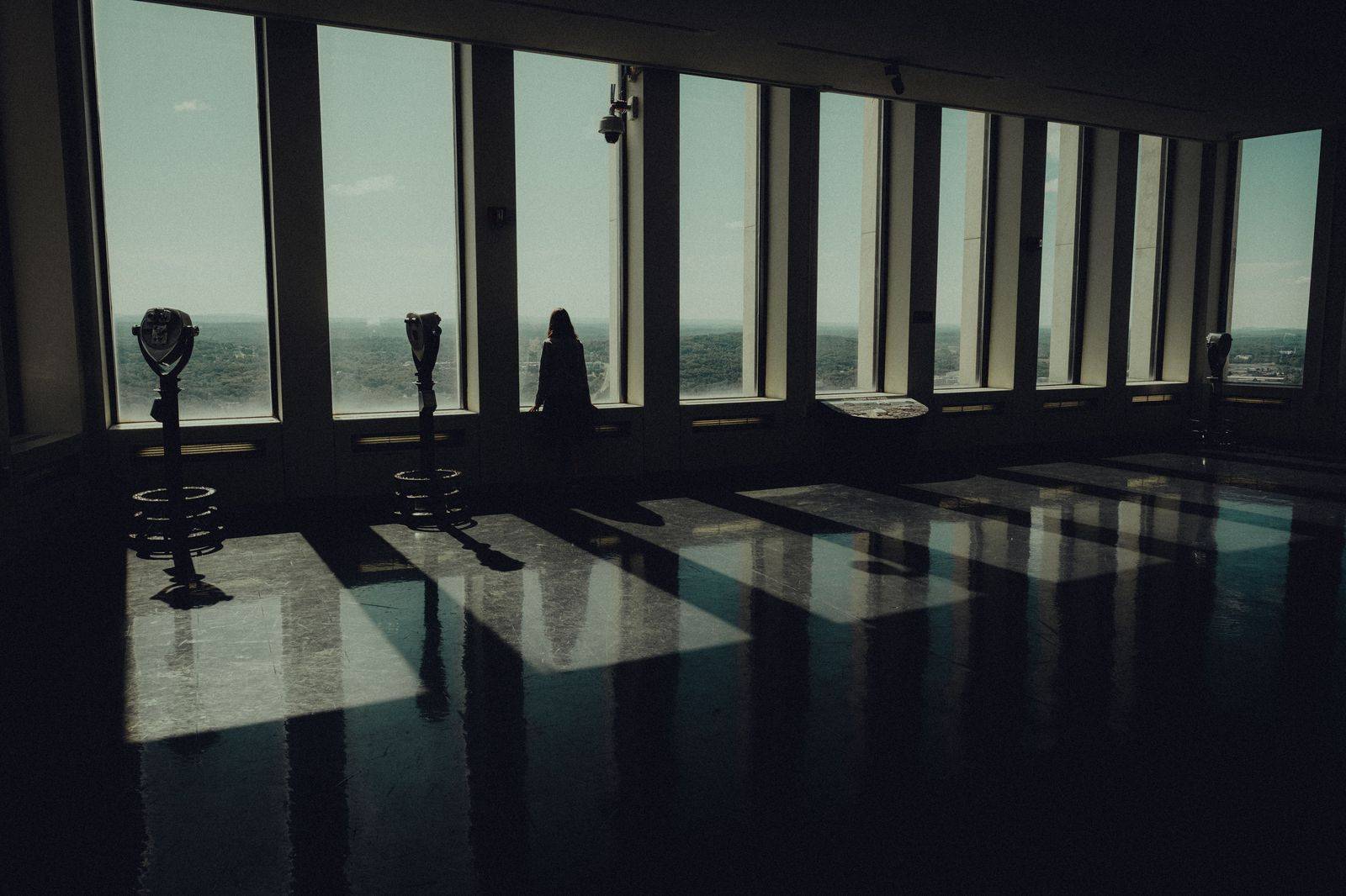 Visitors standing on a glass floor high above the city at an observation deck