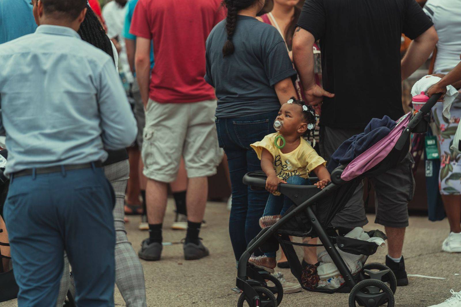 A family with a stroller walking through a summer fair