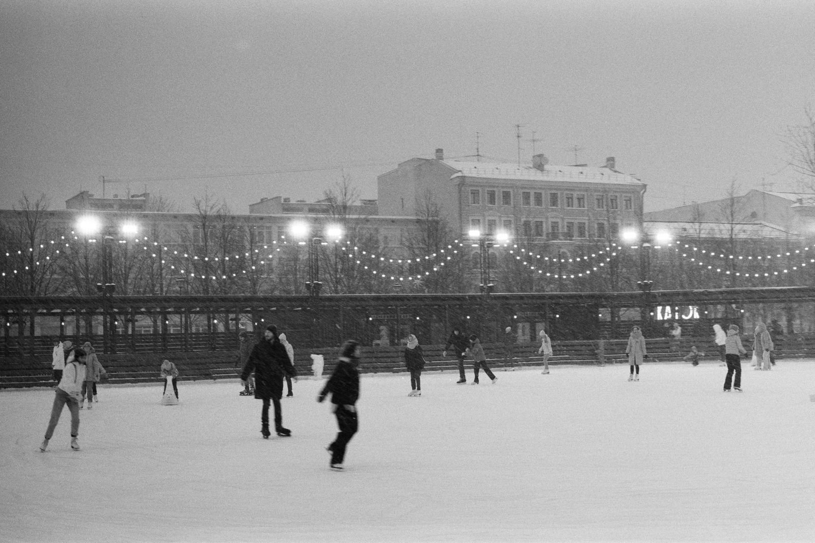 An outdoor skating rink lit up at night in downtown Toronto