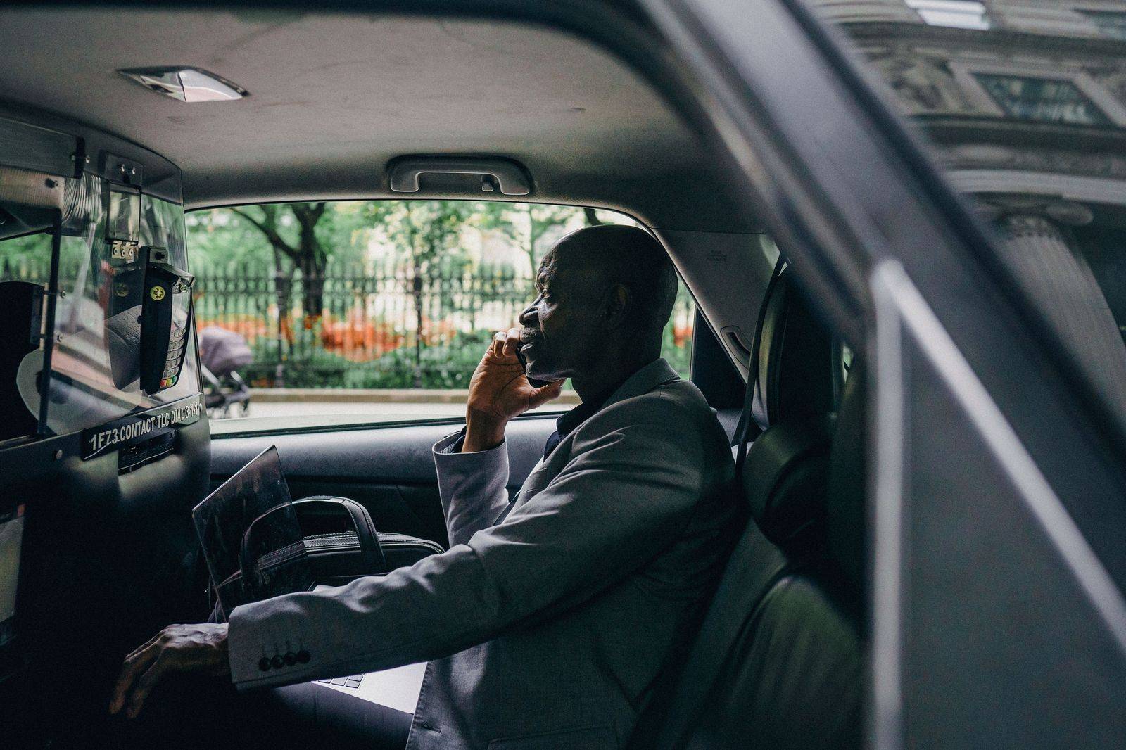 An executive working on a laptop in the back of a chauffeured car between Toronto meetings
