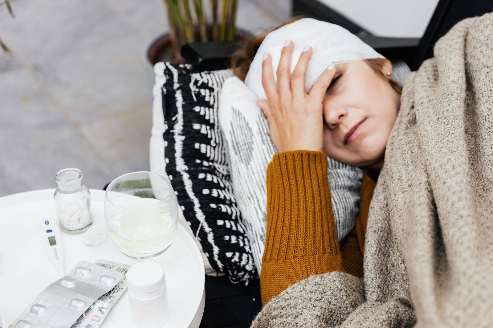 A patient resting at home on a couch with a blanket after day surgery