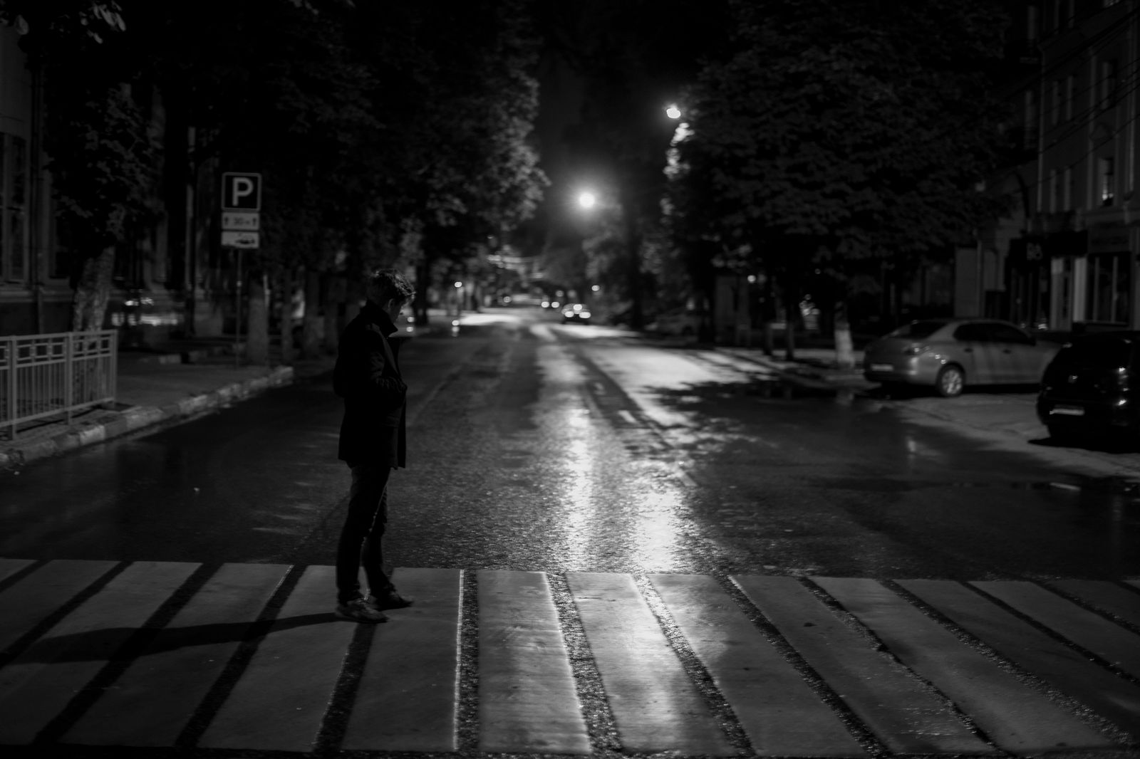 A black sedan waiting at a downtown Toronto curb in the evening