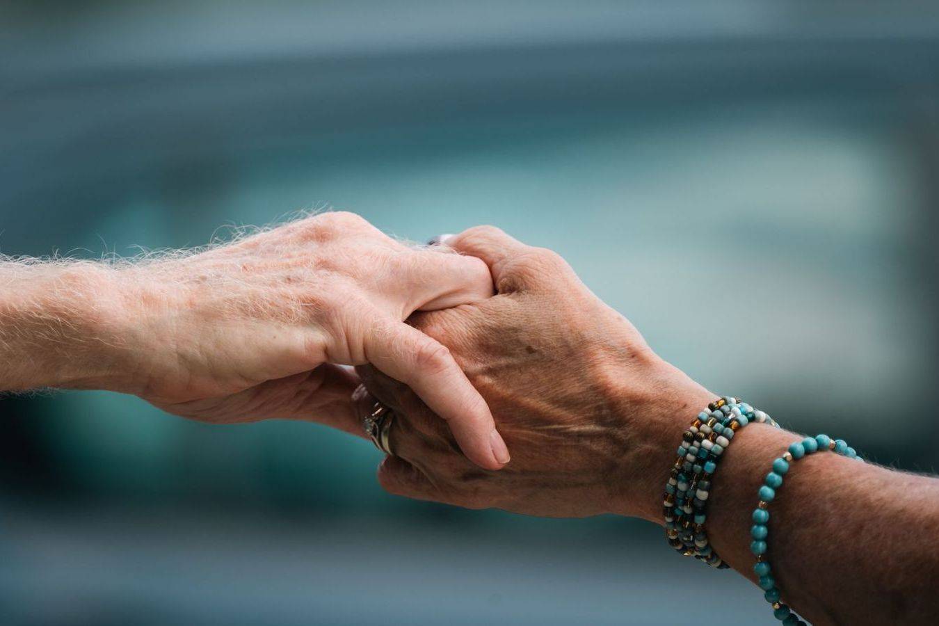 Family members holding hands in quiet support at a funeral