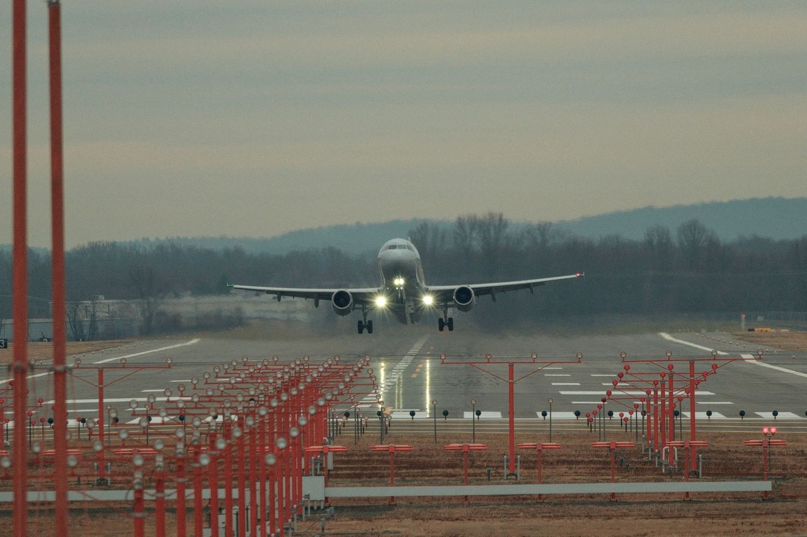 An airplane landing at dusk with runway lights on near Toronto