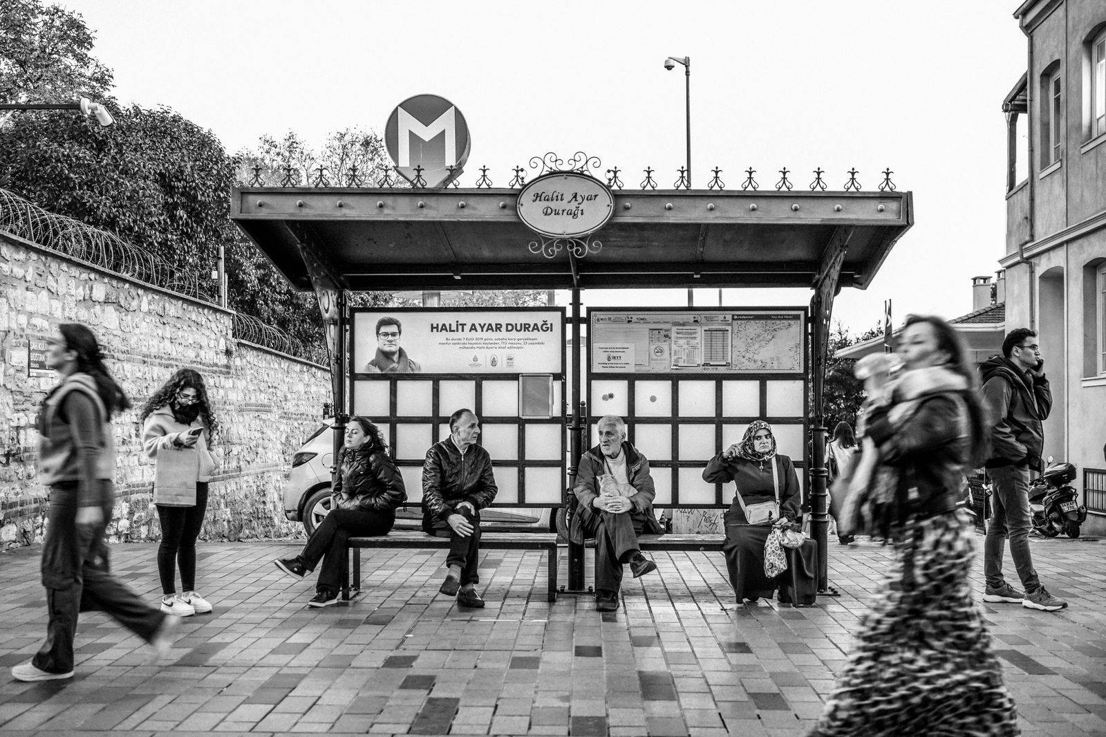 A family with suitcases waiting at a bus stop