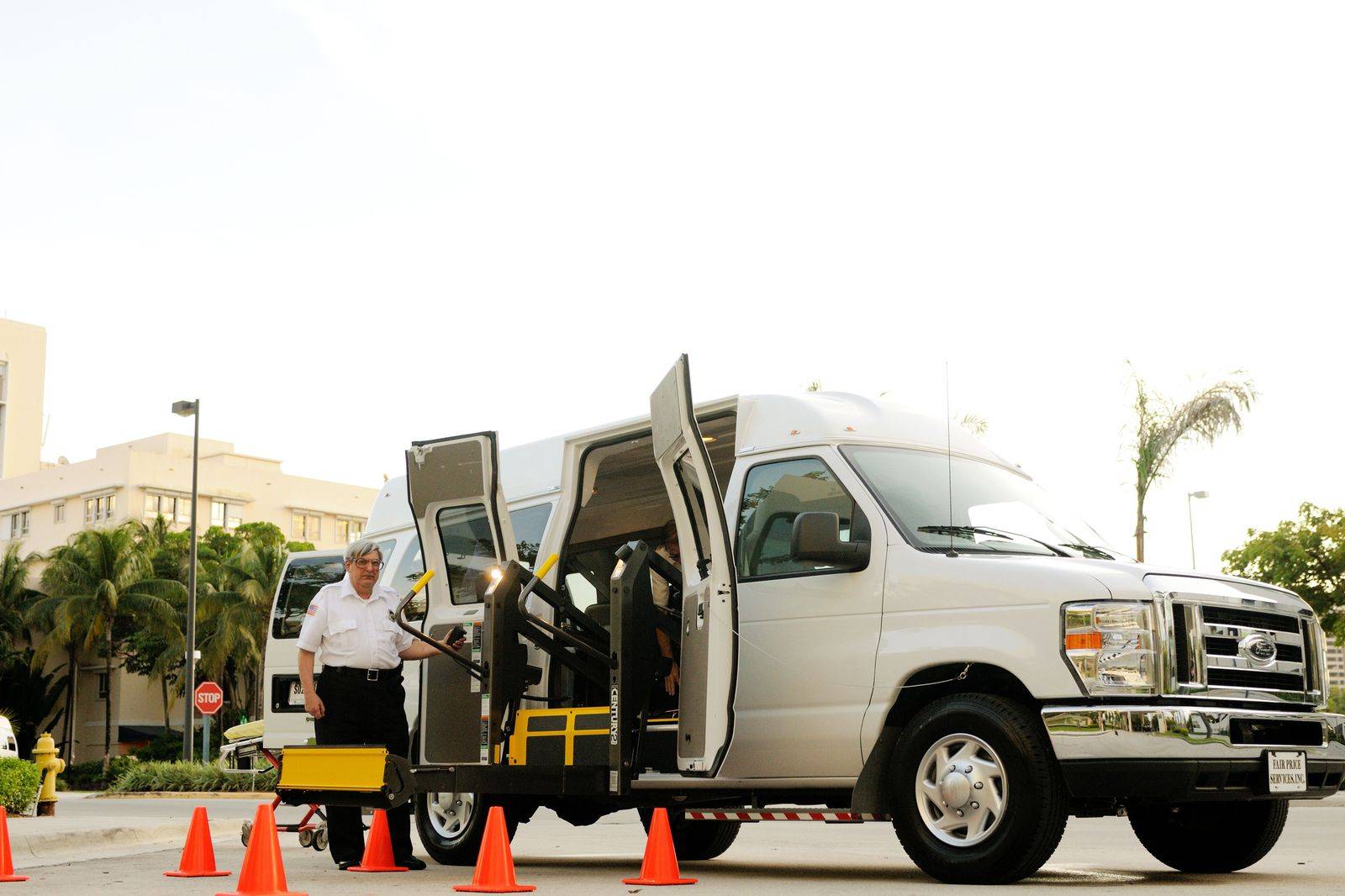 A chauffeur holding the door of a black passenger van