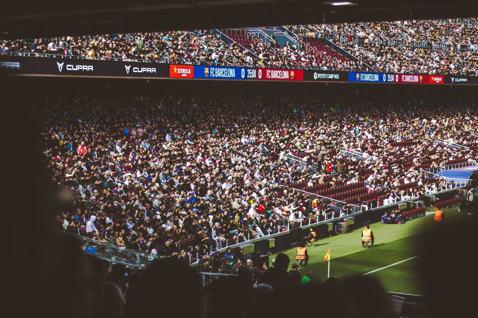 A soccer stadium crowd under lights on a summer evening