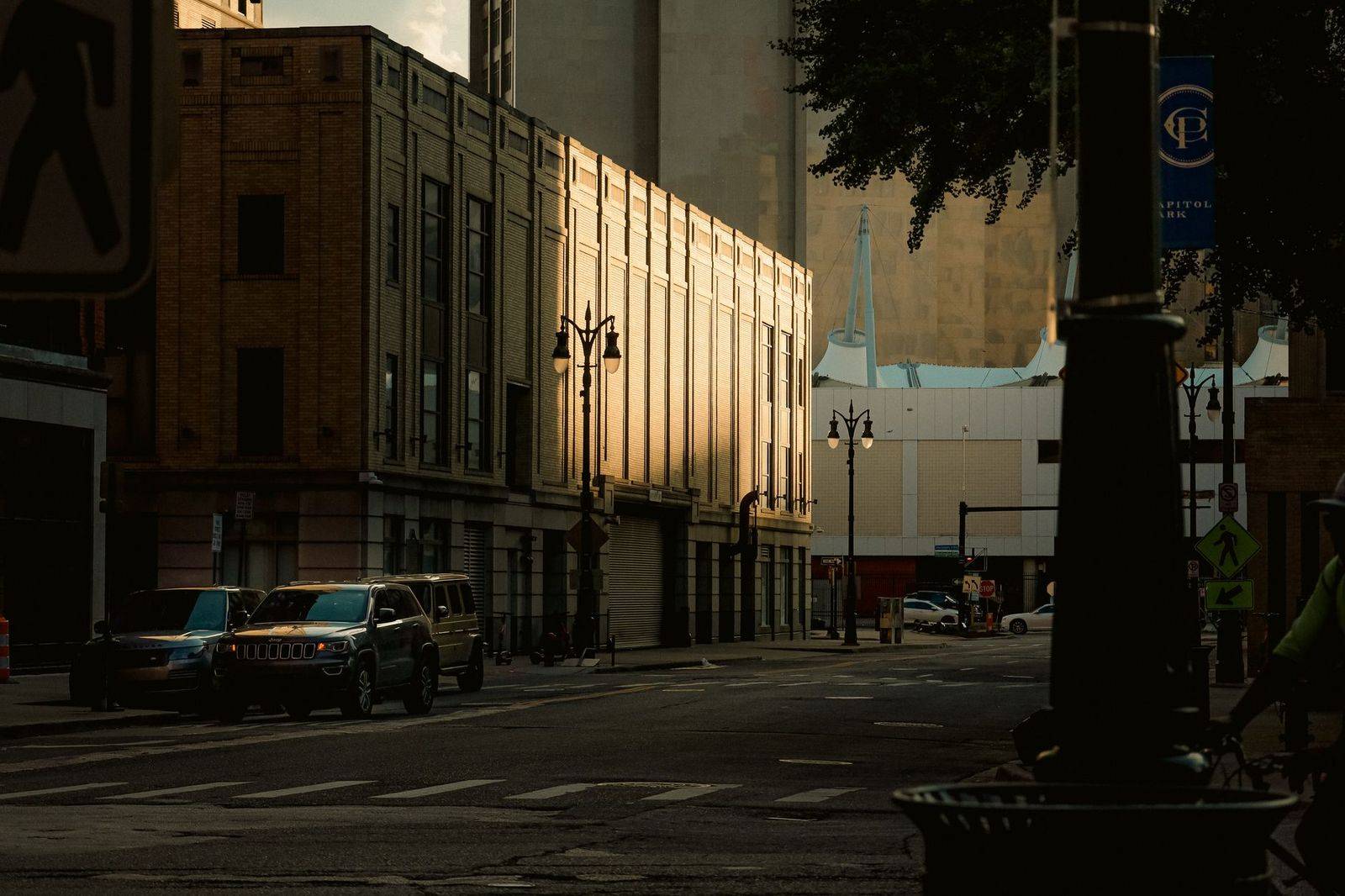 A black SUV waiting on a downtown side street in the early evening