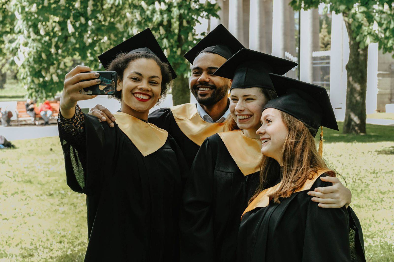 Graduates in caps and gowns celebrating outside a university building