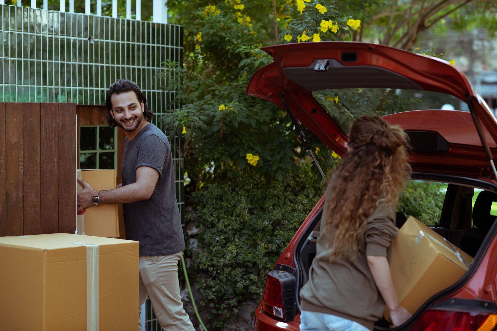 A family loading suitcases into the trunk of a black car before the drive from London to Pearson