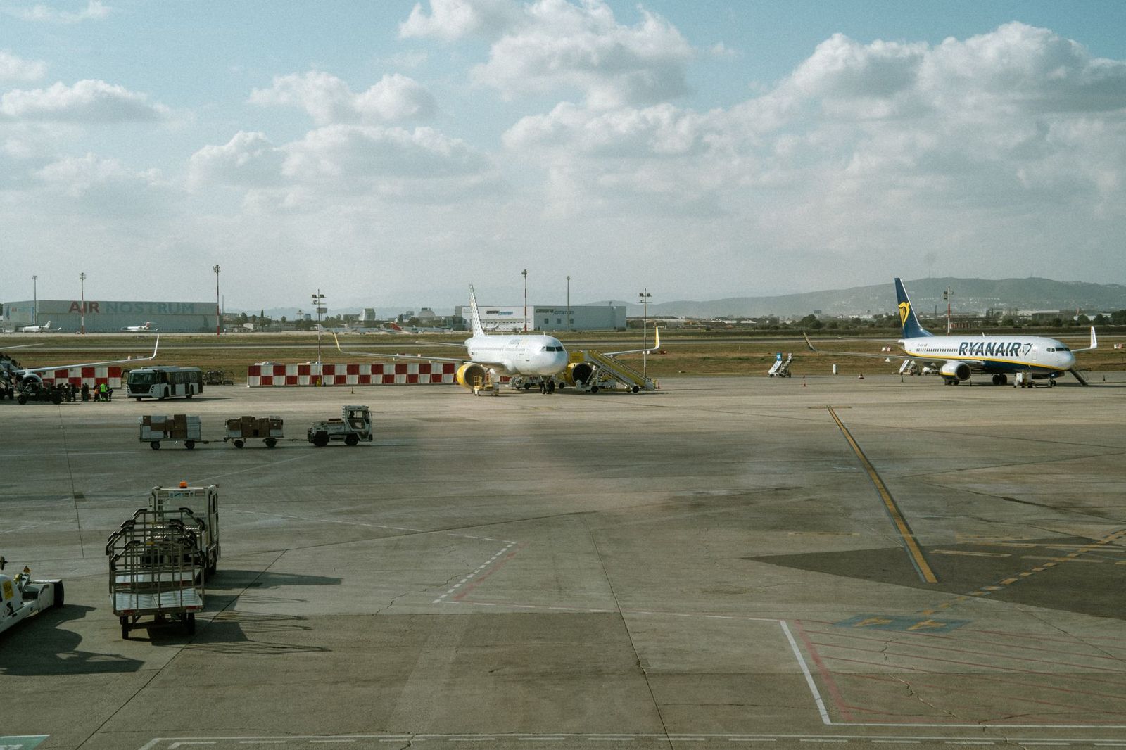 Travellers with suitcases walking through a busy airport departures hall