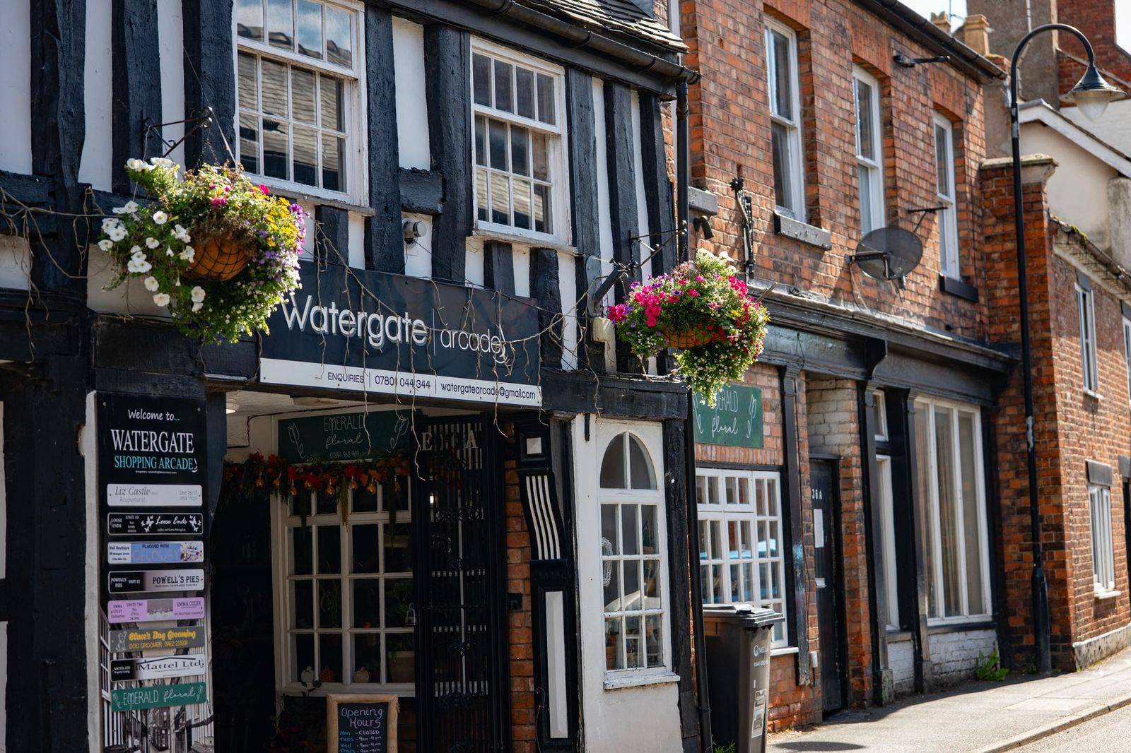 The flower-lined main street of a historic small town in the afternoon