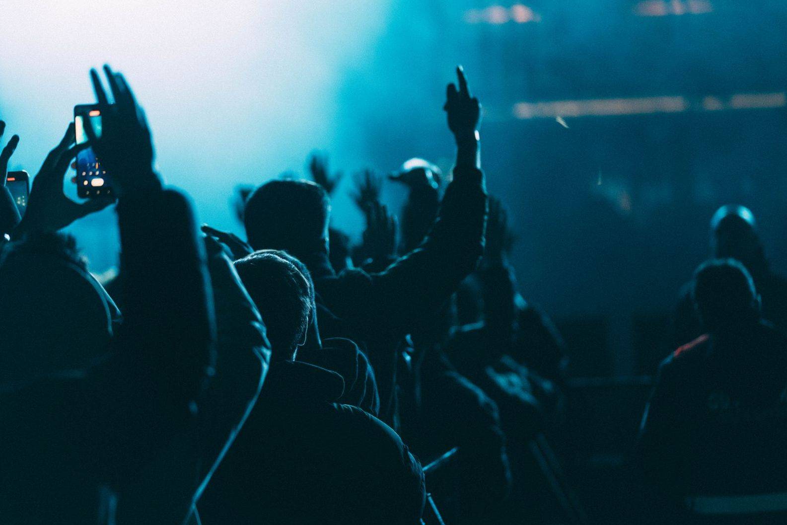 A crowd with hands raised in a small Toronto music venue during a festival set