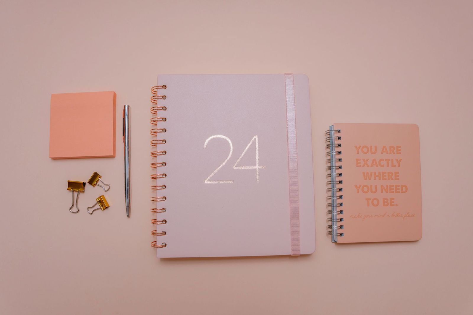 A planner and calendar open on a desk while a group organiser compares party bus dates