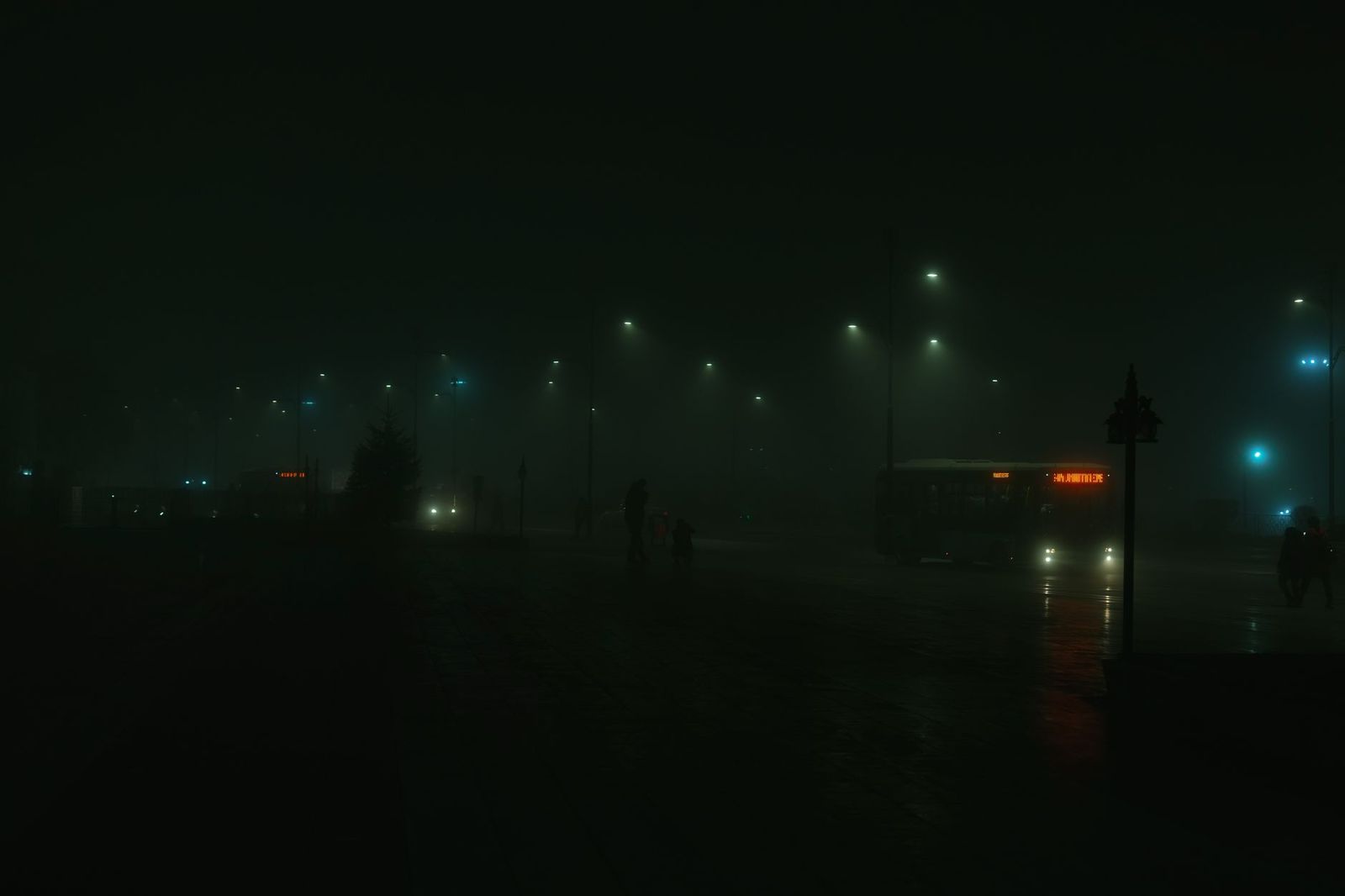 A party bus on a Toronto highway at dusk with its headlights on