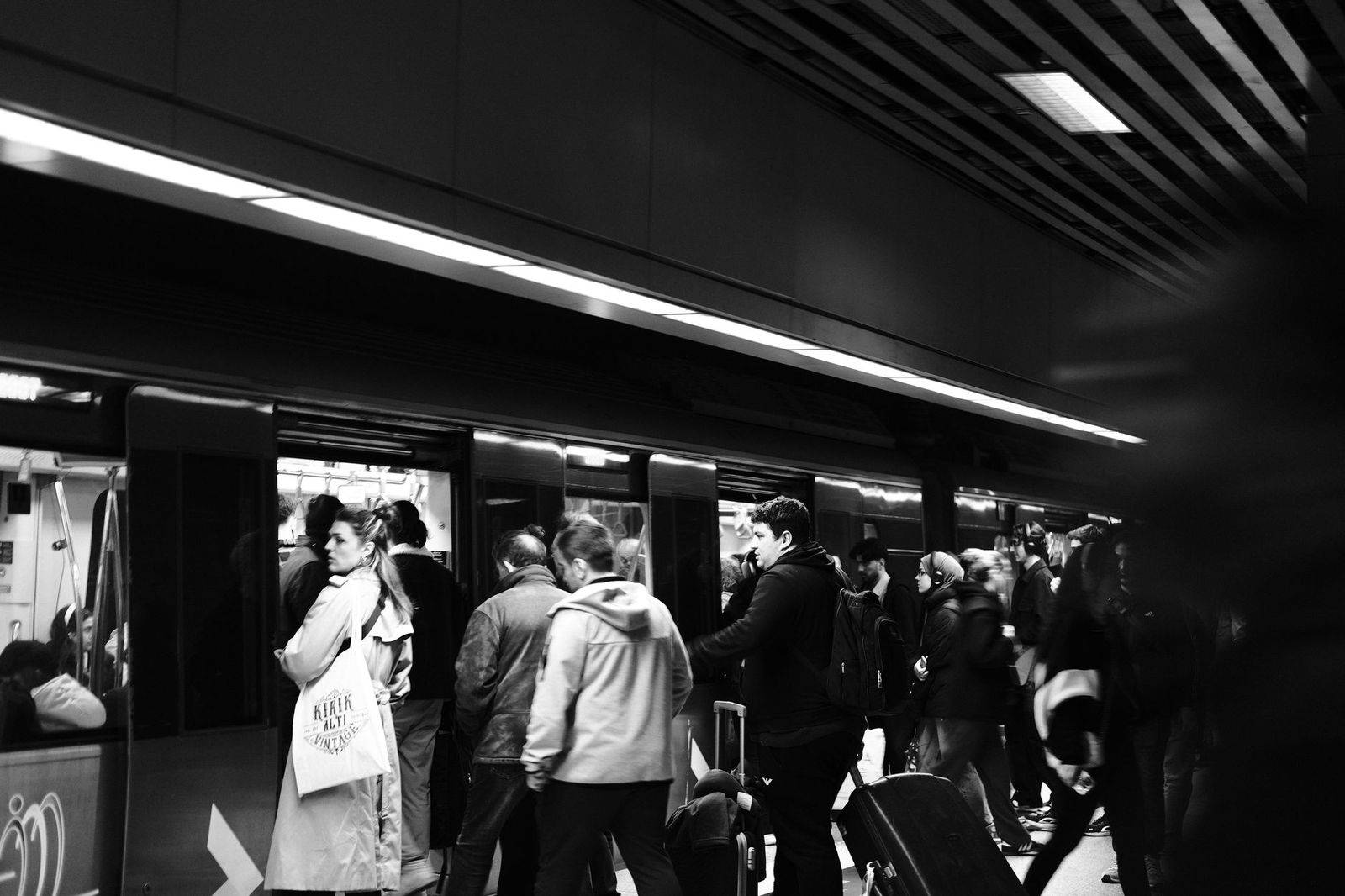Travellers with luggage trolleys coming through the doors into the Pearson arrivals hall