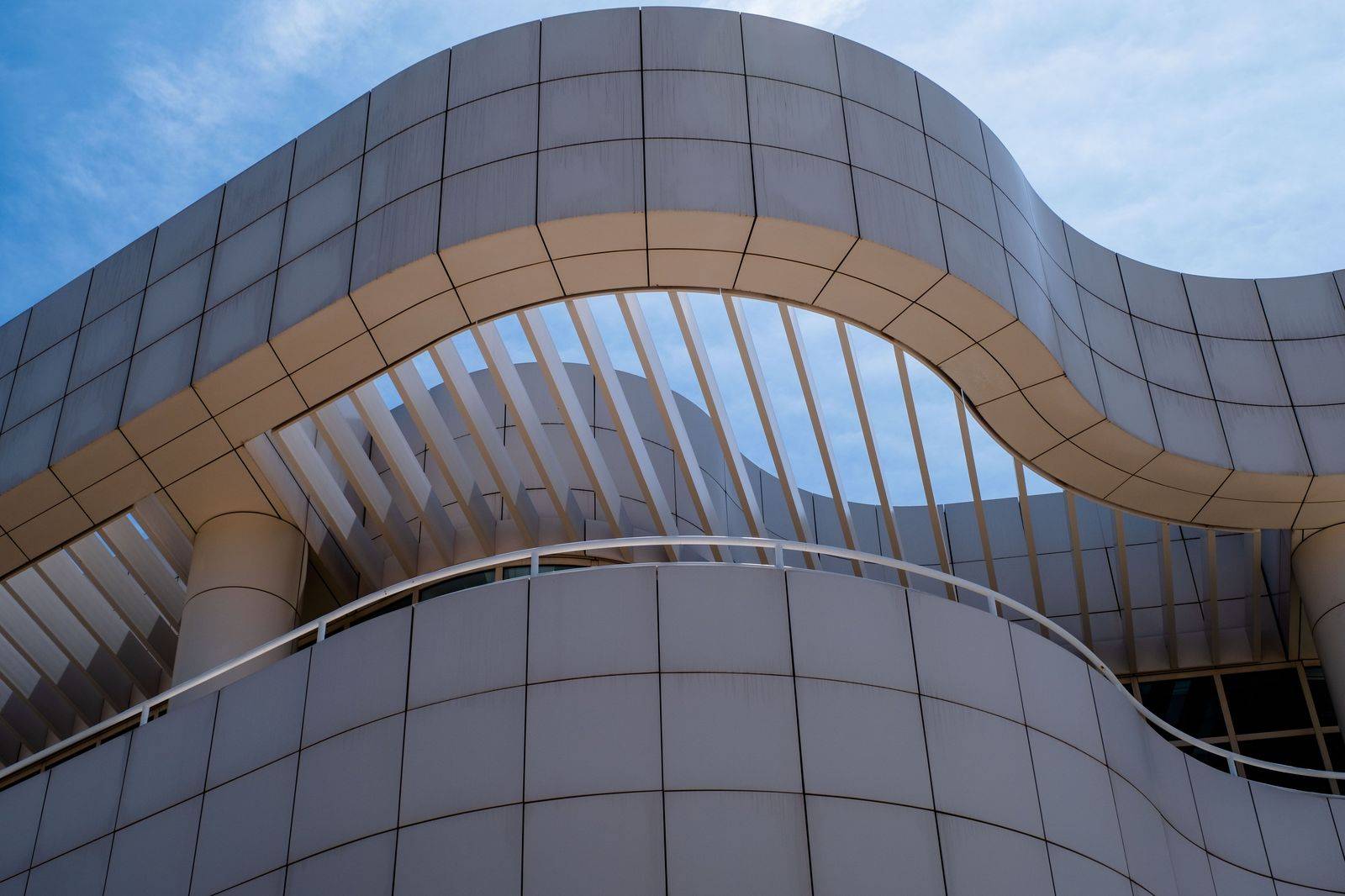 The modern glass facade of a museum on a busy street