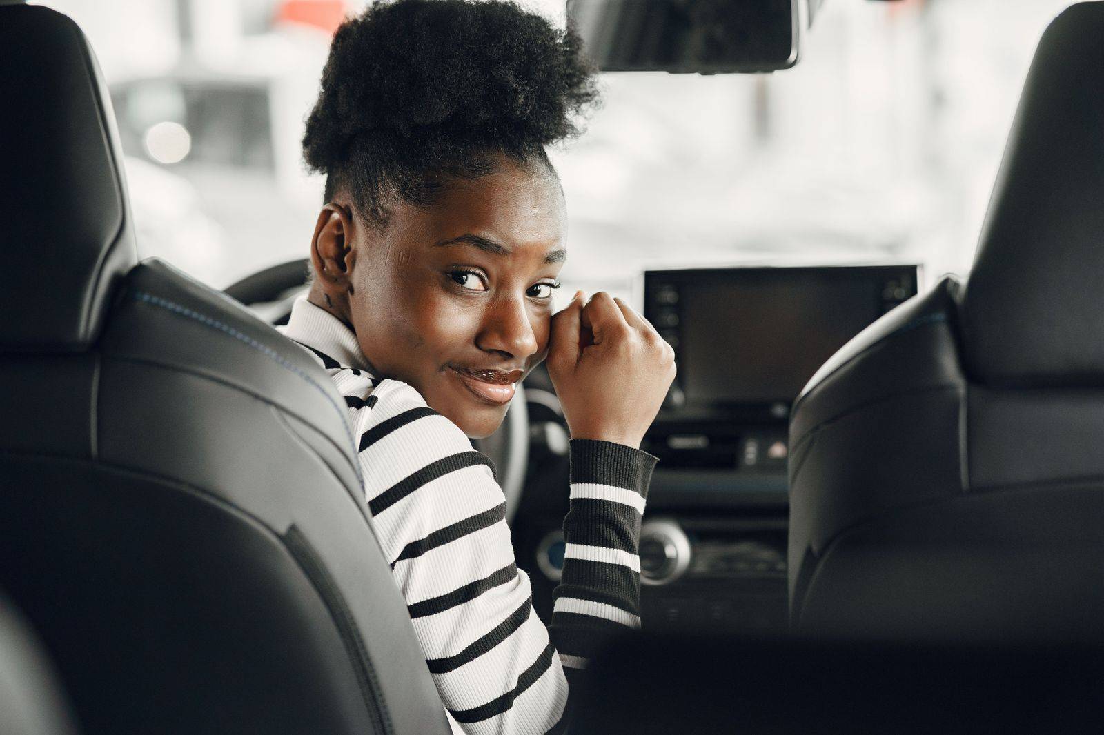 A patient resting under a blanket in the back seat of a car