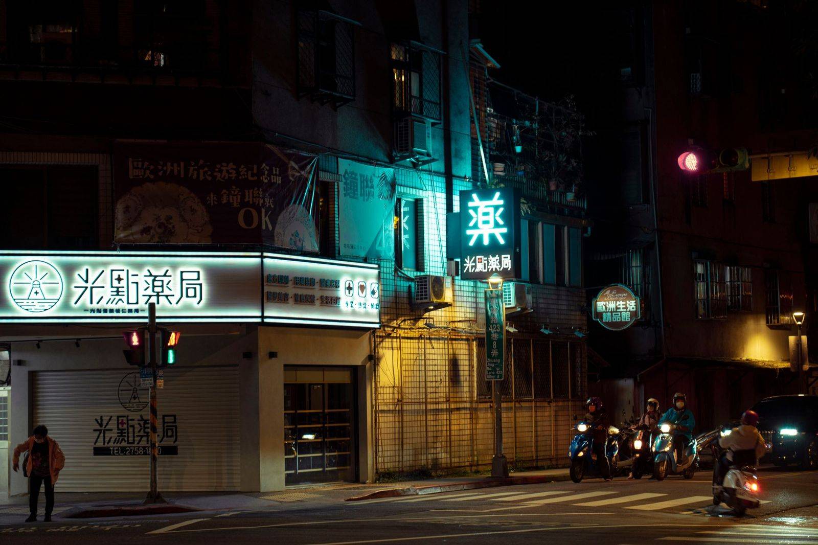 A busy downtown intersection at night with traffic lights and moving cars