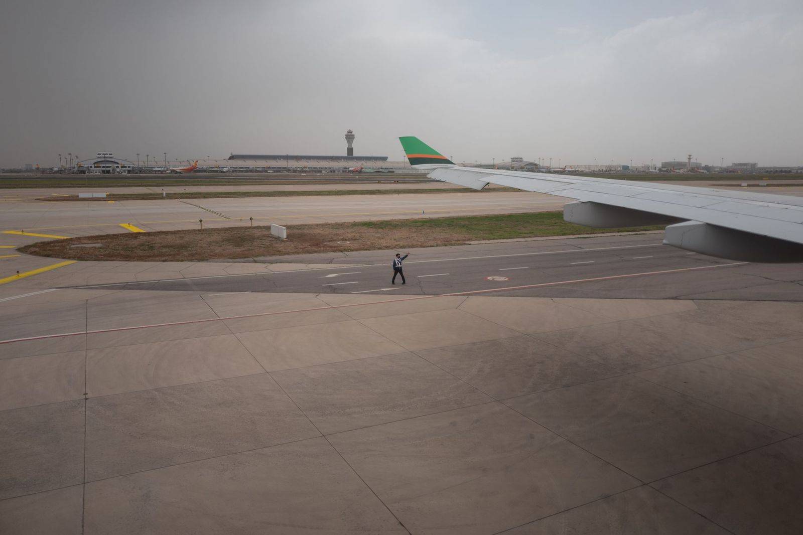 A business traveller walking through an airport terminal with a carry-on