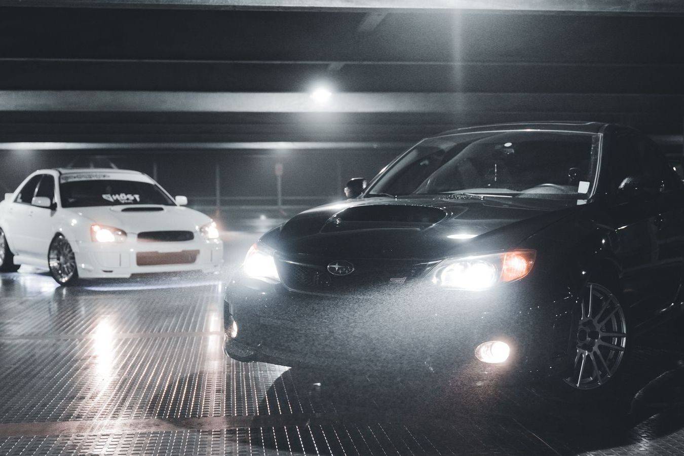 A black sedan waiting outside a restaurant entrance at night in Toronto