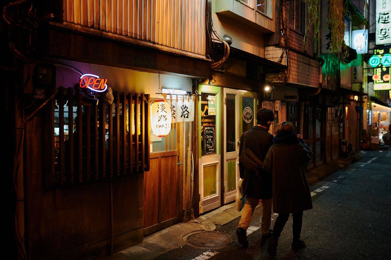A couple leaving a Toronto restaurant at night to a waiting car