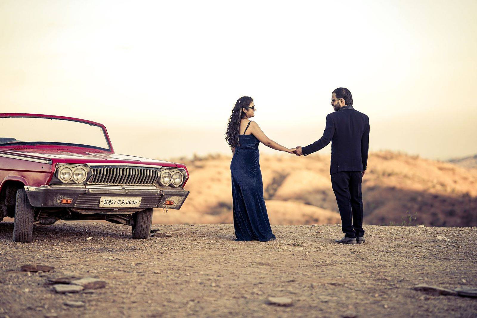 A couple in formal wear stepping out of a black car for an evening gala