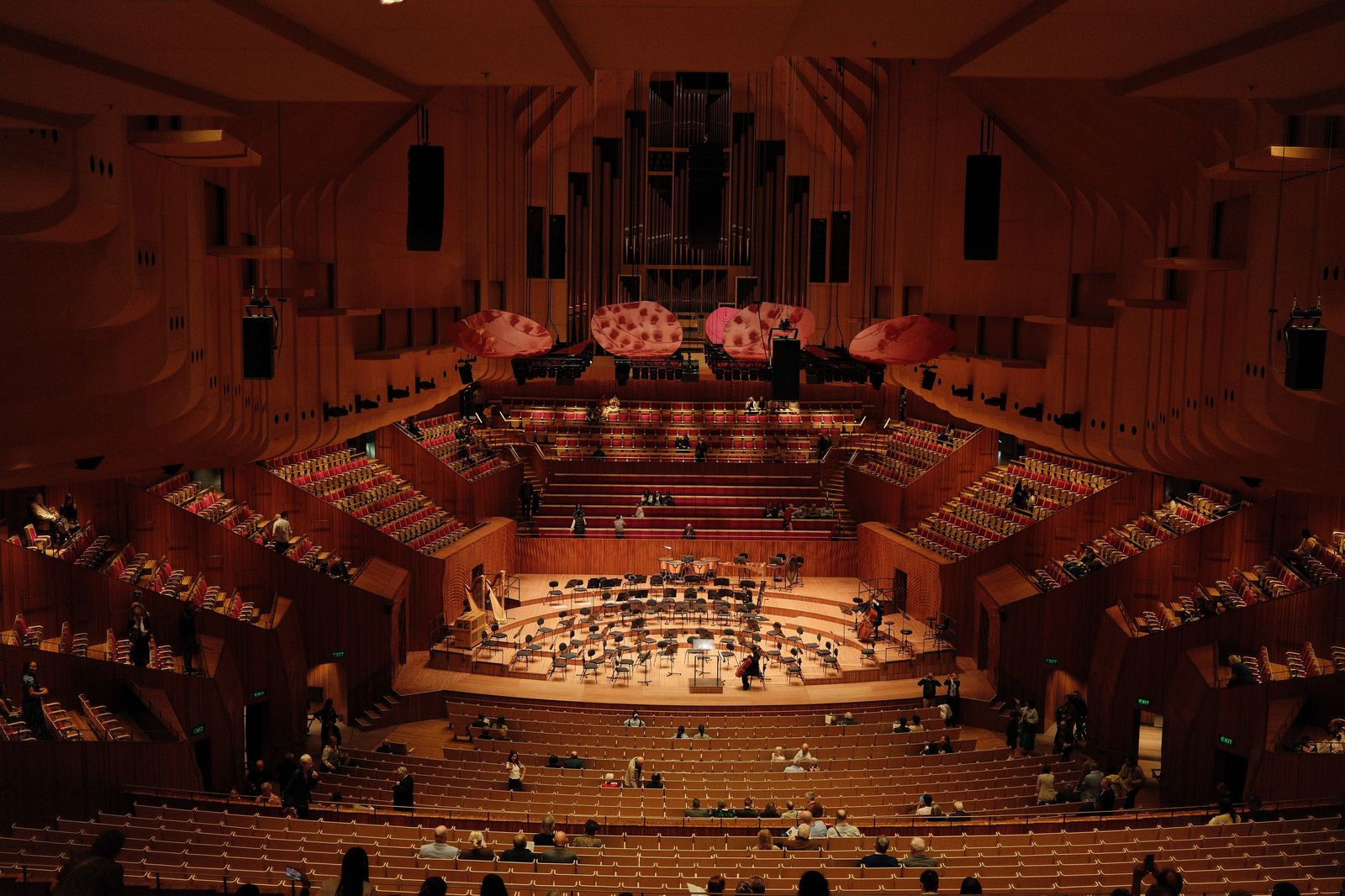 The interior of a concert hall with an orchestra on stage and rows of seats
