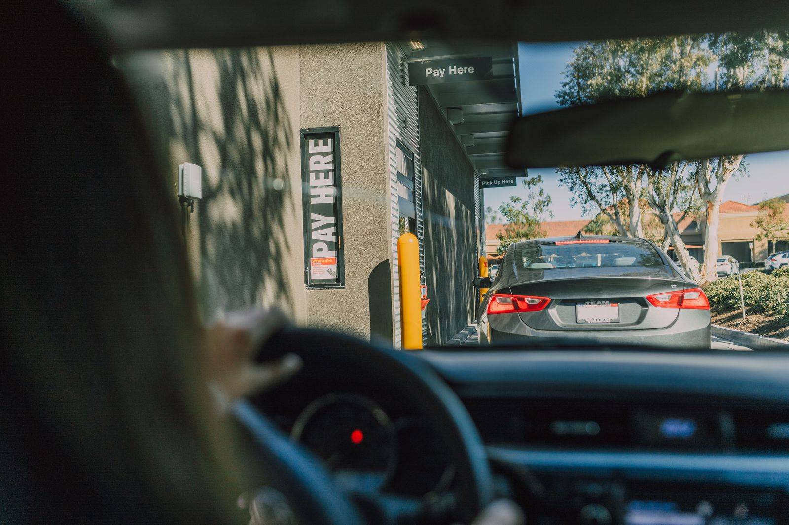 A line of black cars waiting outside a downtown hotel