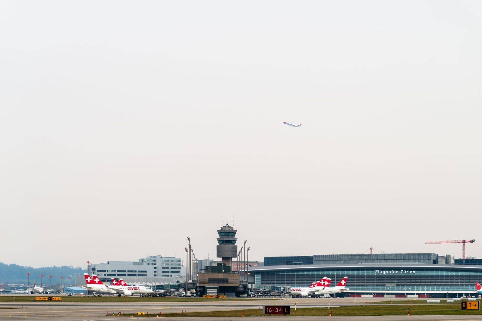 An airport control tower at dusk over private aircraft parking at Toronto Pearson