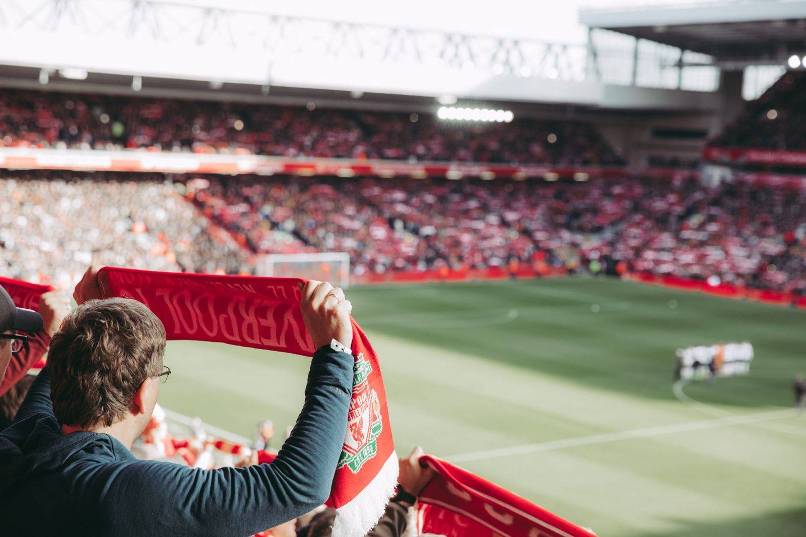 Soccer supporters in scarves cheering in the stands