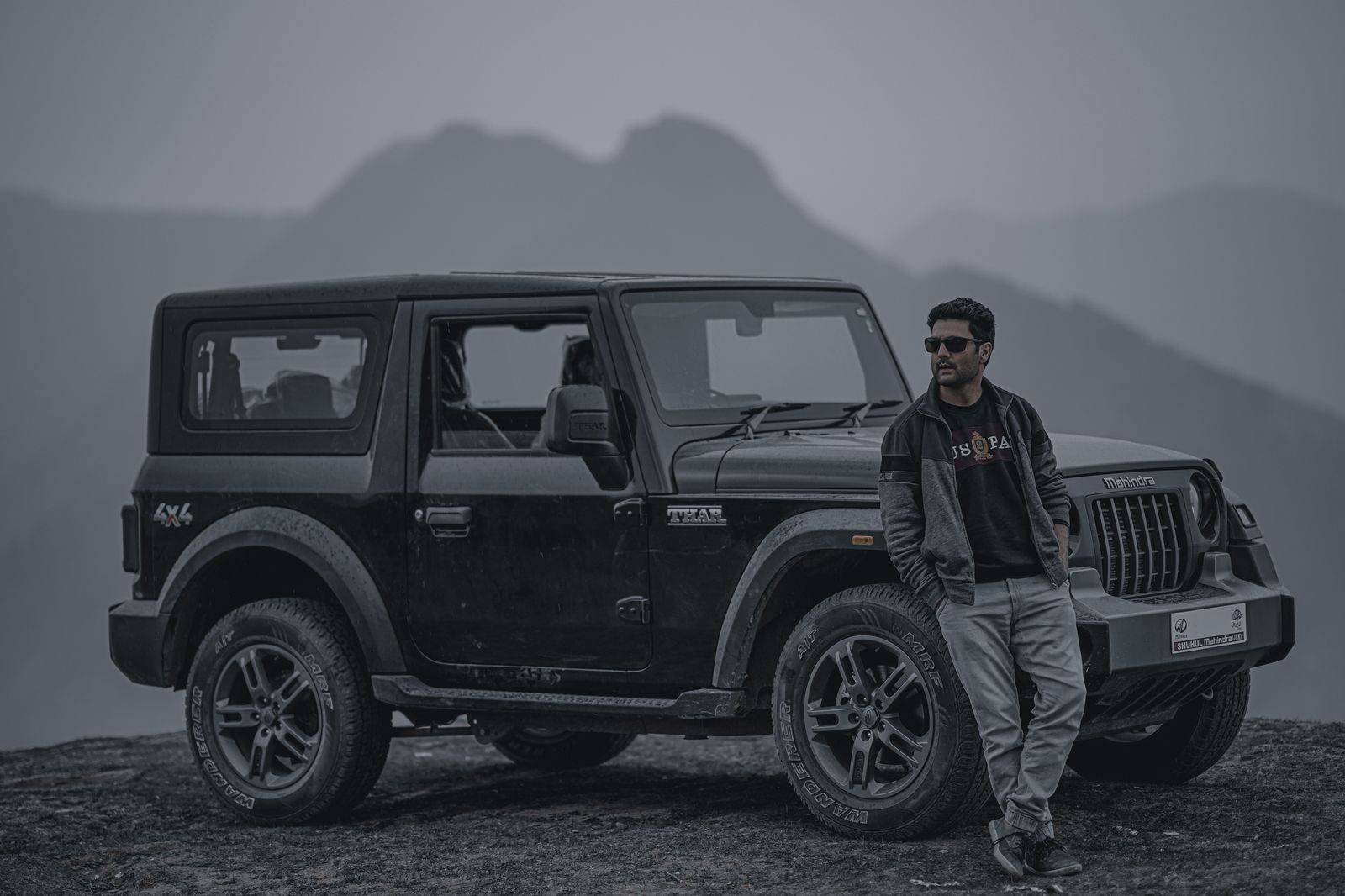 A chauffeur waiting beside a black SUV