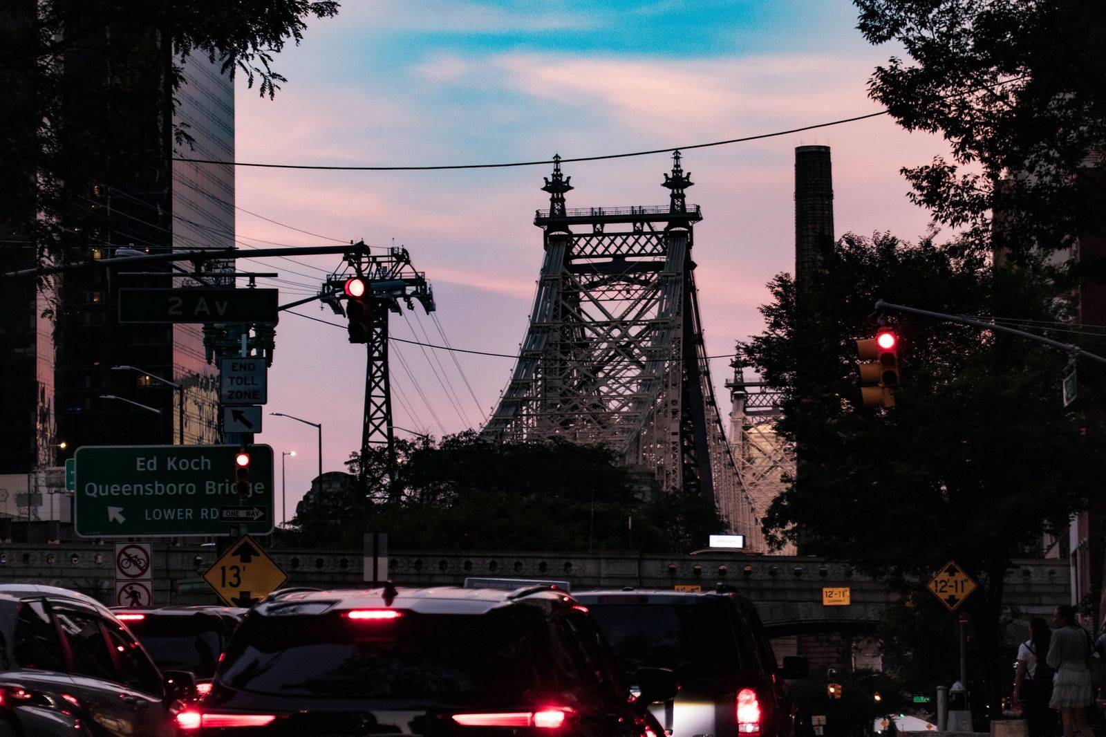 A black SUV on a wide city avenue at dusk