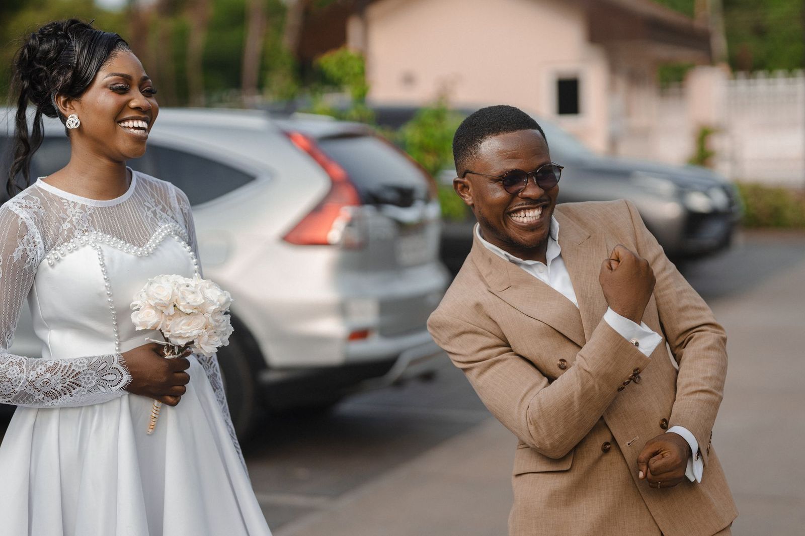 A bride and groom stepping into a black car after their wedding ceremony