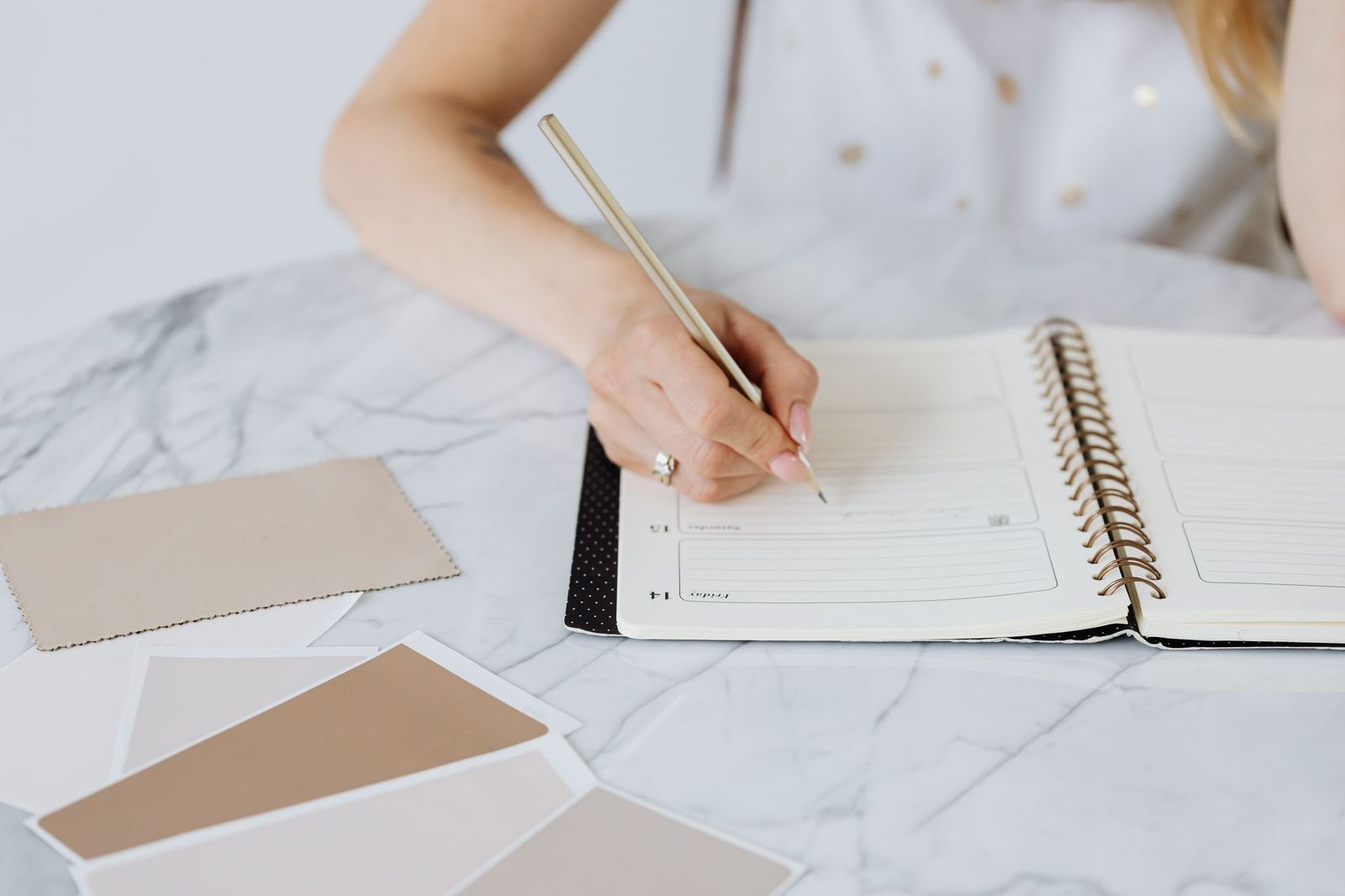 A wedding planner's notebook with a timeline on a table beside flowers