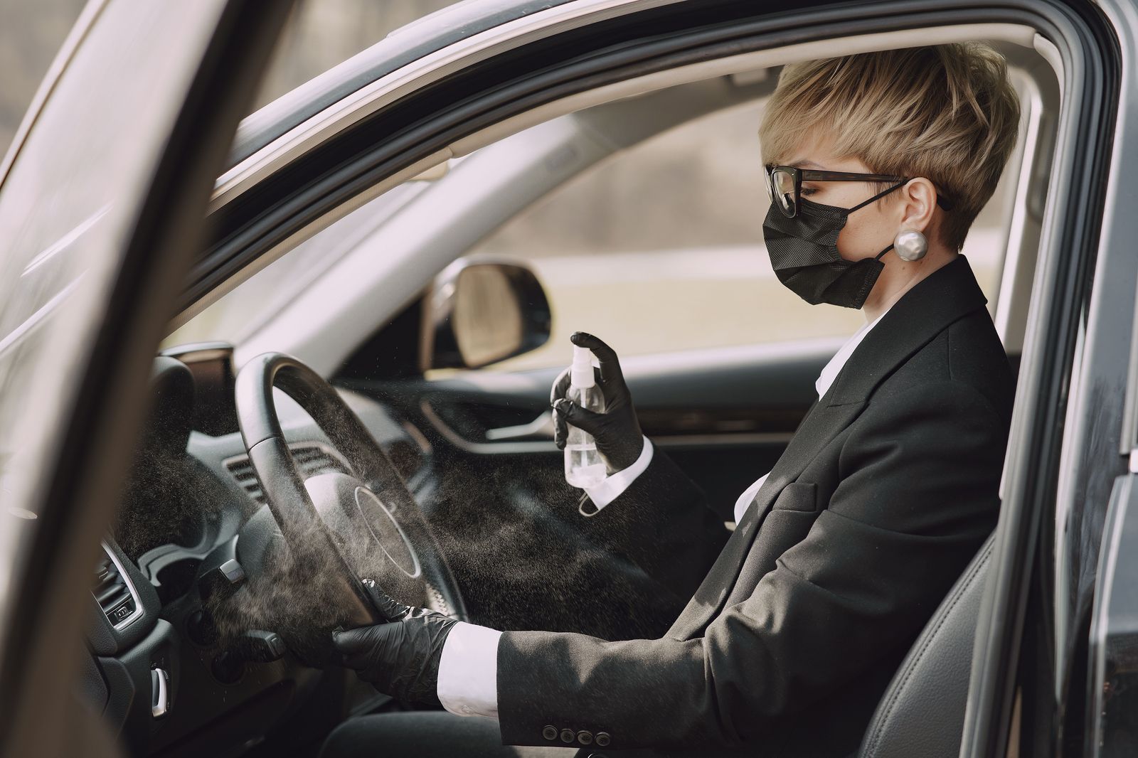 A chauffeur cleaning a black car before the next Toronto booking