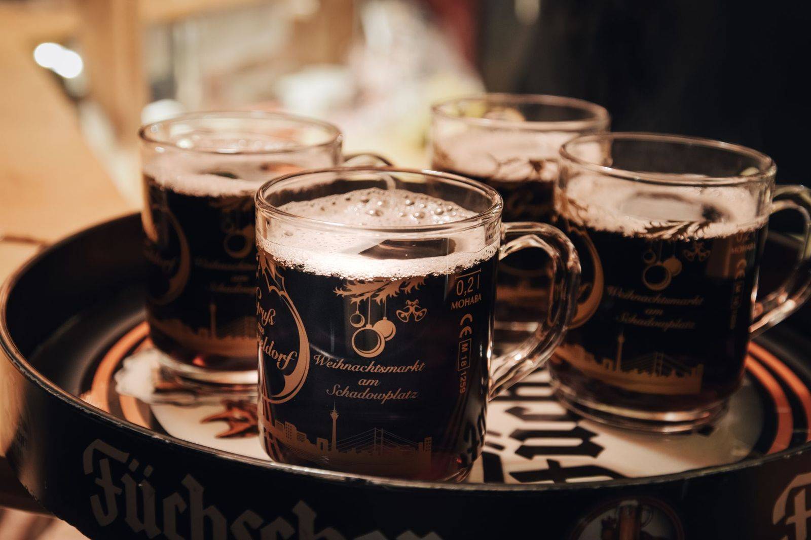 Paper cups of mulled cider at a Toronto Christmas market stall in the evening