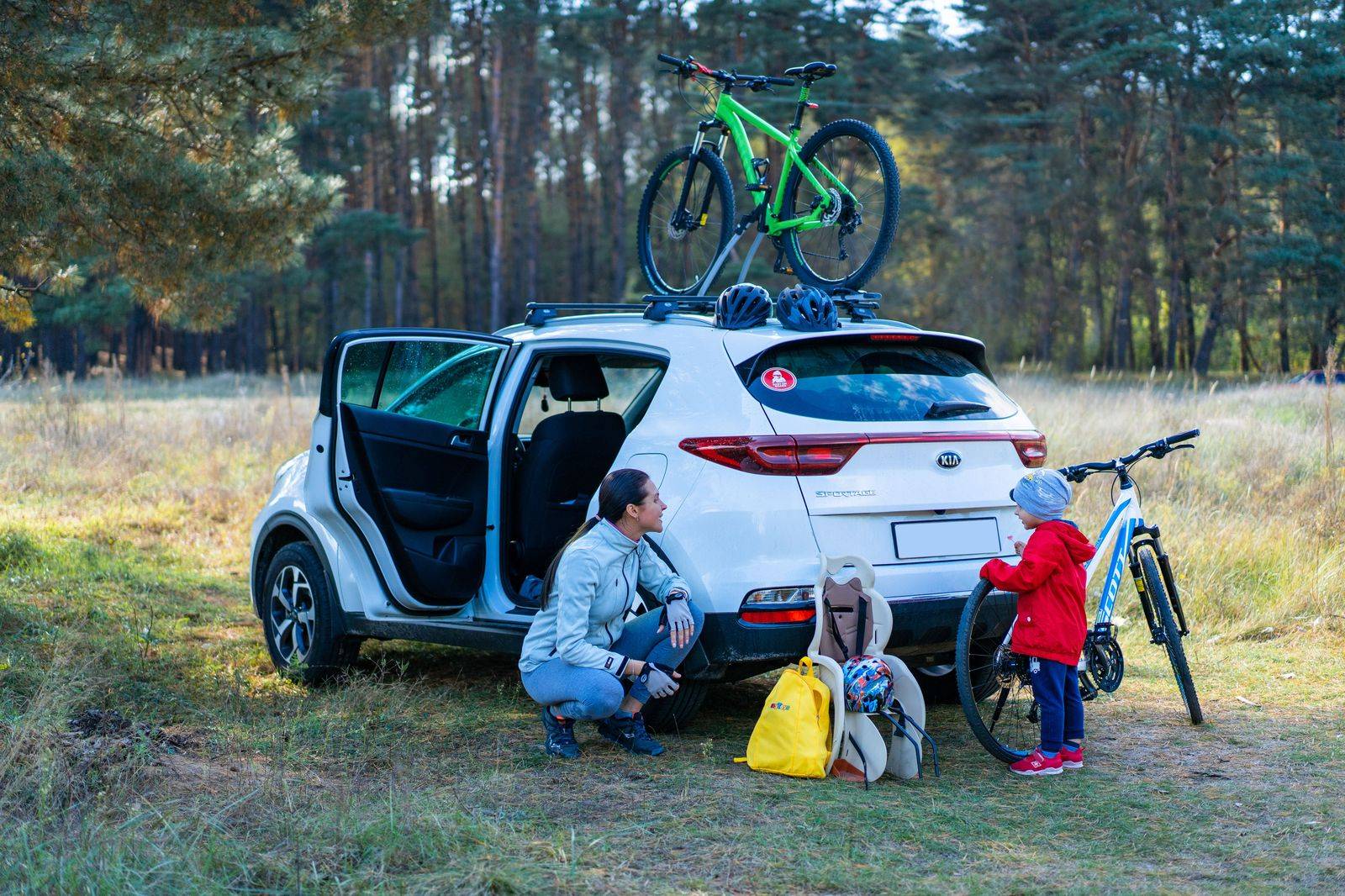 Family loading suitcases into the back of an SUV in a driveway before a trip