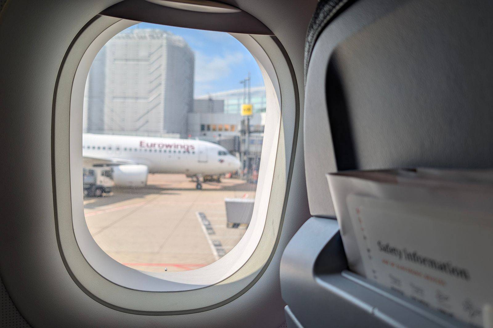 View of an airliner's tail through a terminal gate window