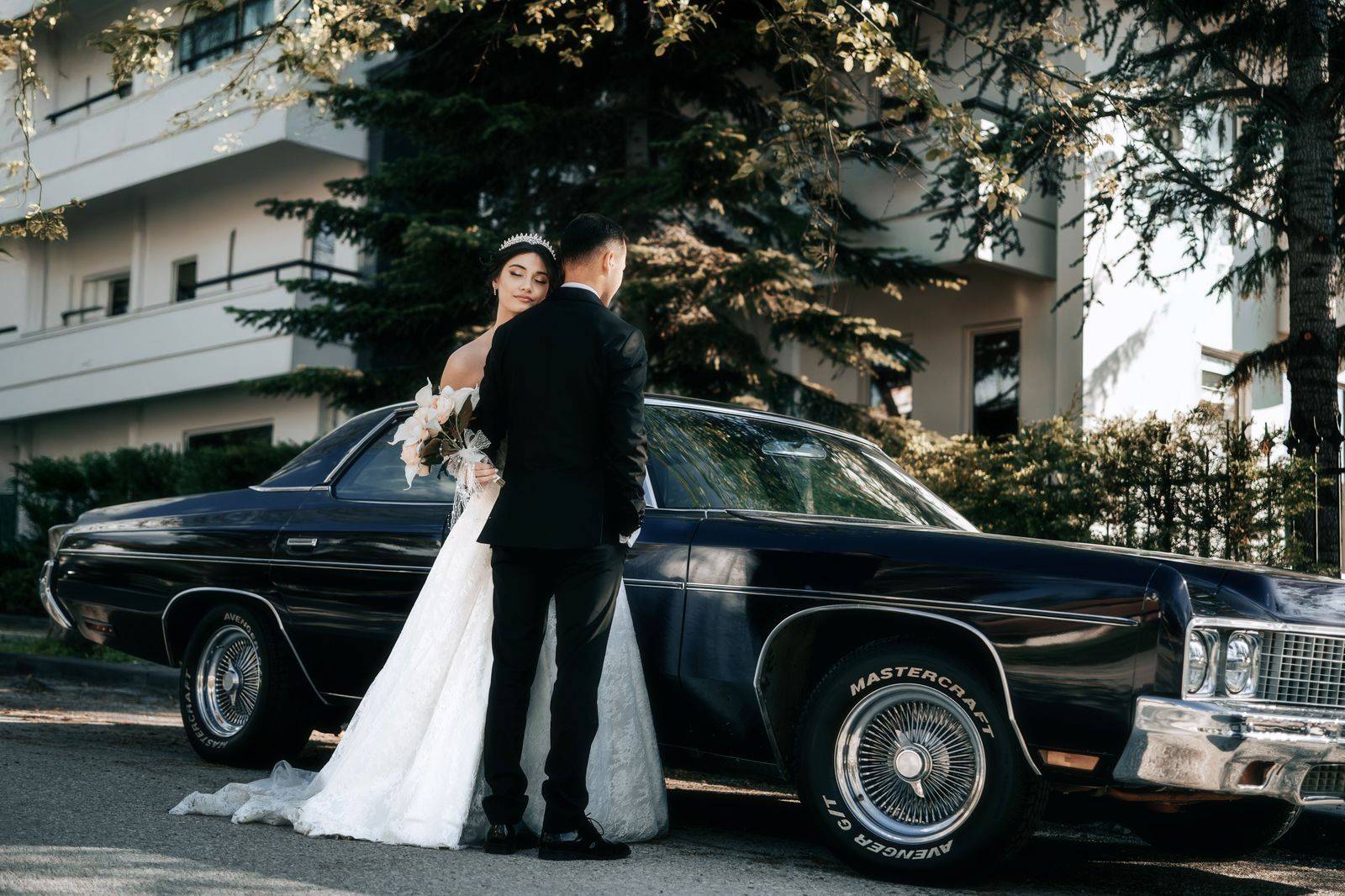 A wedding couple stepping out of a black car at a Brampton banquet hall