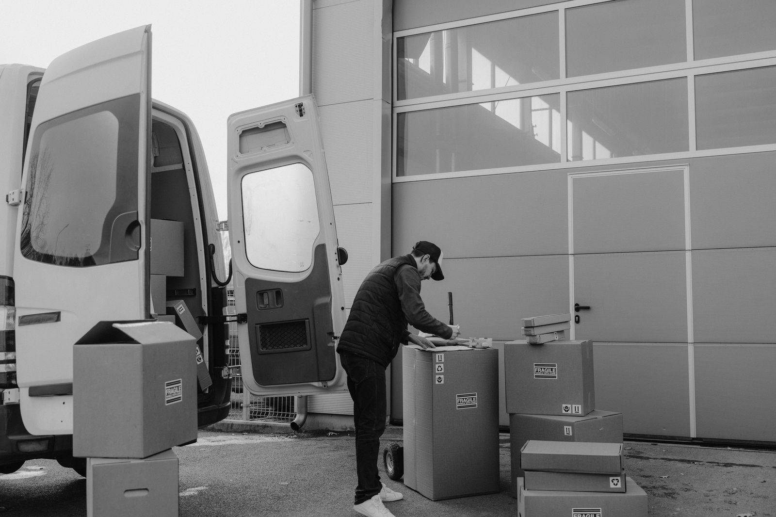 A chauffeur loading luggage into a black SUV outside a lakeside resort