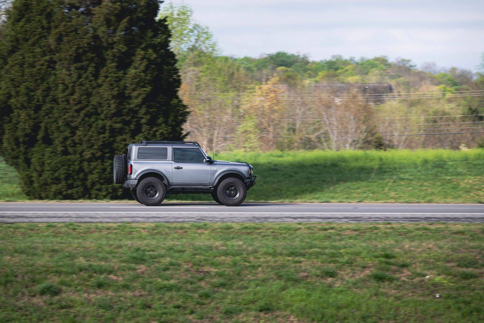 A black SUV on a highway through open farmland